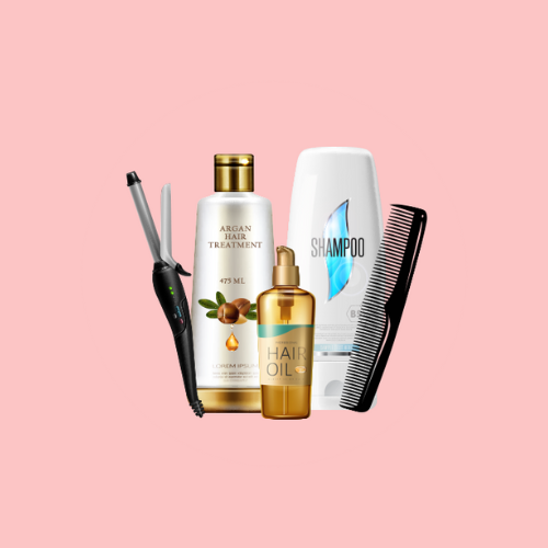 A curling iron, argan hair treatment, shampoo, hair oil, and a black comb are arranged together on a pink background.